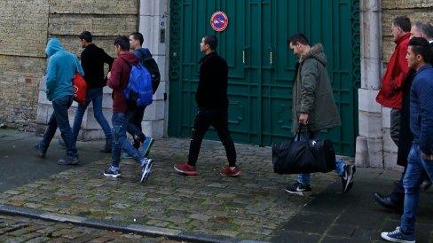 Afghani adolescent migrants walk under a French flag