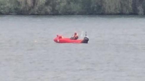 A blurry, zoomed-in image of a red rescue boat on open water. 