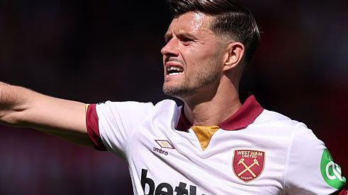 Aaron Cresswell holds out his right arm as he instructs team-mates during a game for West Ham