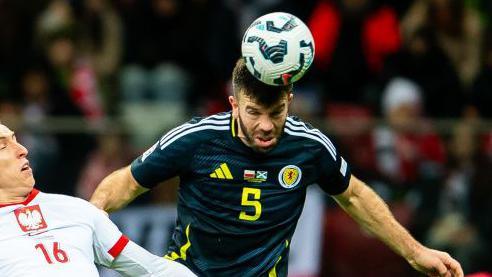 Grant Hanley heads clear during Scotland's 2-1 win in Poland on 18 November   