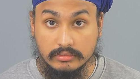 Custody photo of Vickrum Digwa, a man with a beard, a grey jumper and a purple turban looking to the camera.