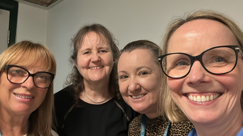 Four women – two of them wearing glasses – smiling at the camera.