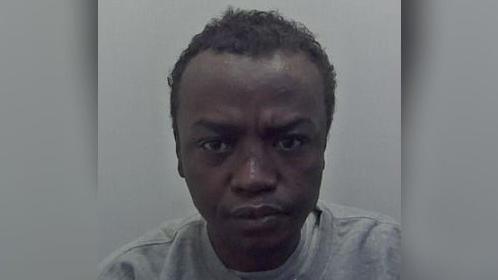 Mohammed Hgar looks at the camera in a police mugshot. He is wearing a grey jumper and has short dark hair.