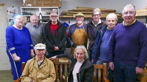 Wells Community Shed members are standing around a bench they made for Tessa Munt. In the background 