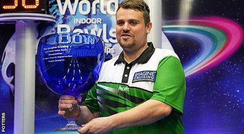 Jamie Walker holding the World Indoor Bowls Championships 2023 trophy