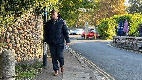 Stuart Worby arrives at Norwich Crown Court wearing brown shoes, black trousers and a black puffa jacket. 