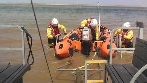 A lifeboat and three crew members.