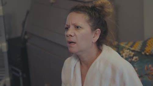 A head and shoulders picture of Sacha Goulden who is wearing what appears to be a white dressing gown shirt and looking to the left of the frame with a shocked facial expression.