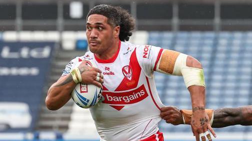 St Helens' Sione Mata'utia evades the tackle of Huddersfield Giants' Kevin Naiqama as he scores scores his side's second try during the Betfred Super League Round 24 match between Huddersfield Giants and St Helens at John Smith's Stadium on September 1, 2024 in Huddersfield, England