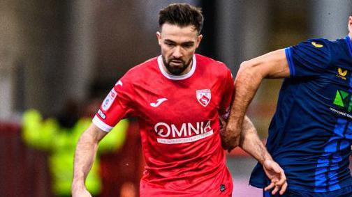 Gwion Edwards of Morecambe is under pressure from Stephen McLaughlin of Mansfield Town during the Sky Bet League 2 match at the Mazuma Stadium in Morecambe, on January 13, 2024