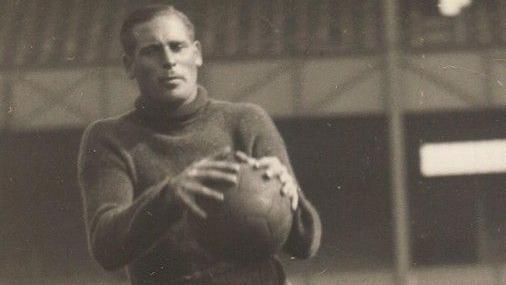 A black and white image of footballer John "Jack" Kirby catching a ball