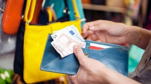 Woman buys handbag in market in Florence Italy