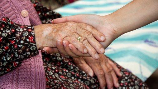 Woman holding an elderly lady's hand