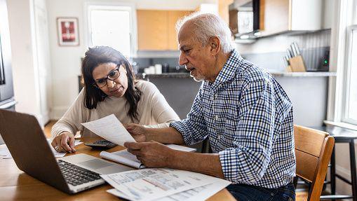 A pensioner couple looking at their household bills