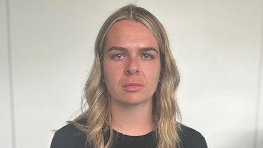 Katherine Errington looks directly at the camera. She has long blonde hair and is wearing a black top