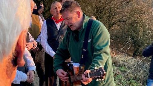 Mike McGrother plays guitar to fellow walkers