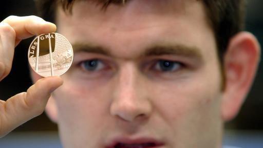 Welsh Rugby Captain Michael Owen holds a limited edition solid gold WRU Grand Slam Winners medal that depicts the Millennium Stadium.