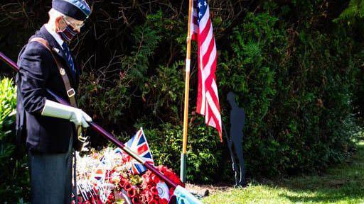 A former soldier lowers a flag at a ceremony at Braunstone Park on Aug 16th 2024