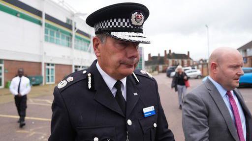 Man in chief constable uniform leaving venue