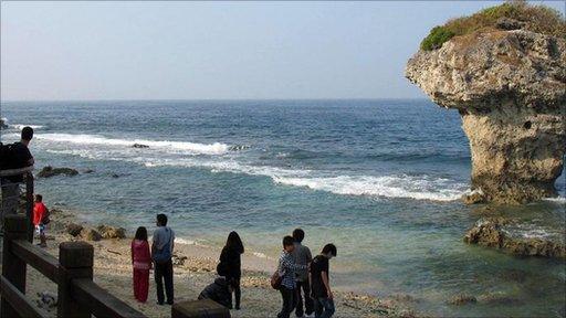 Tourists by coastal rock formation