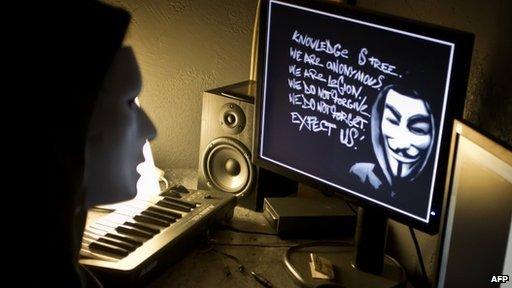 A masked "hacker" poses for a press photo