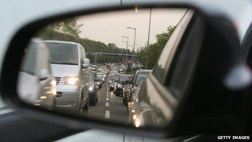 Traffic seen is car's wing mirror