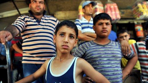 Syrian Kurds stand in the street in the Kurdish town of Jinderes, near the northern Syrian city of Aleppo, on July 22, 2012