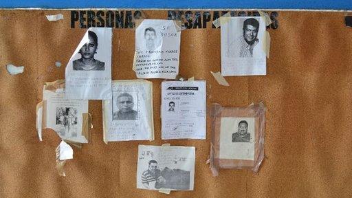 Photos of missing people on a wall outside Acapulco mortuary