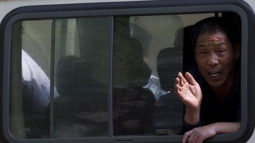 File image of a petitioner trying to draw public attention to his case yelling out from a police van in Beijing on 8 May 2012