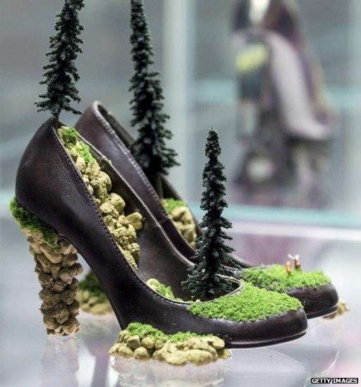 High heels with rocks and miniature trees growing out of them.