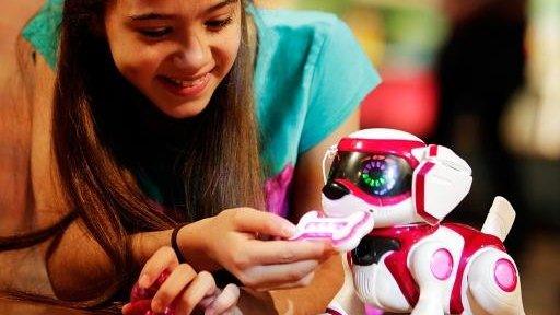 Girl plays with Teksta robotic puppy