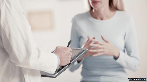 Doctor using a tablet talking to a patient