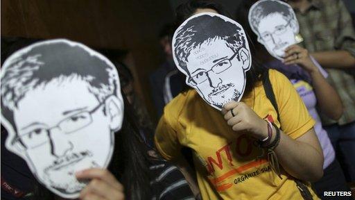 People holding Edward Snowden masks