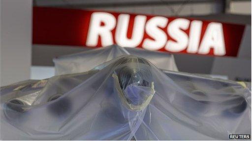 A model aircraft sits under plastic sheeting at Farnborough in front of a Russia sign