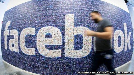 Man walking by a Facebook sign