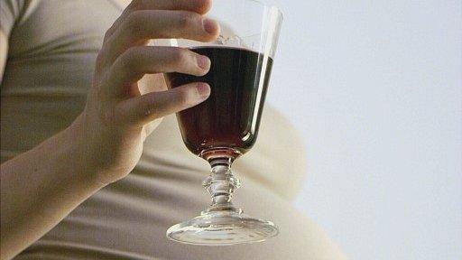 Pregnant woman holding glass of wine