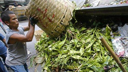 Woman throws food waste into a bin