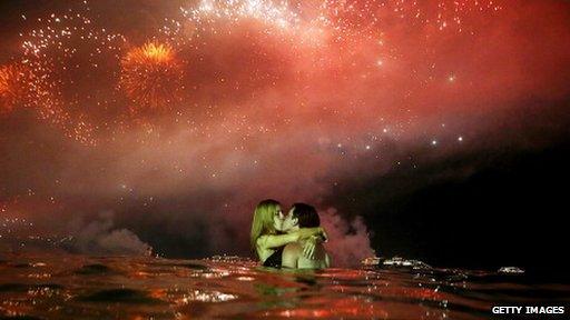 couple kissing with fireworks overhead