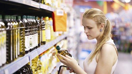 Woman checking price of cooking oil