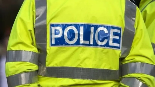 The back of a police officer wearing a high-vis jacket