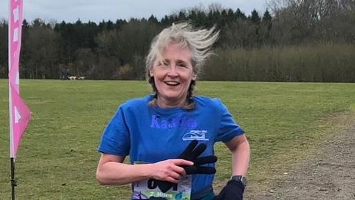 A woman in blue top running 