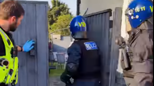 Police officers entering property gates 