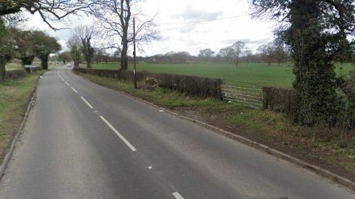 A road with a gate to a field