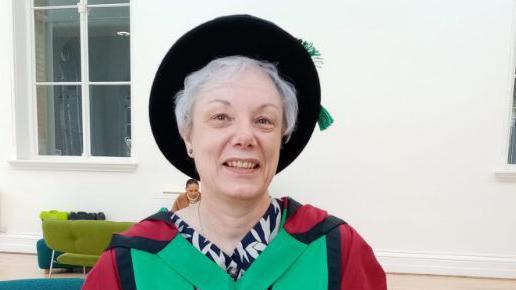 Carol Vaughan, informal portrait wearing a university graduation gown