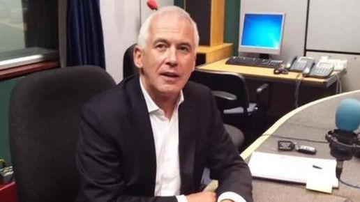 Garvan O'Doherty sitting at a radio desk. He is wearing a white shirt and black jacket.