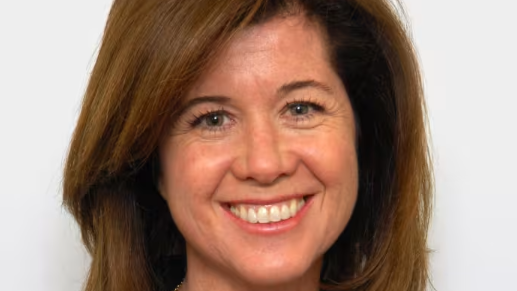 Elizabeth MacDonough has brown hair and is smiling in front of a white backdrop