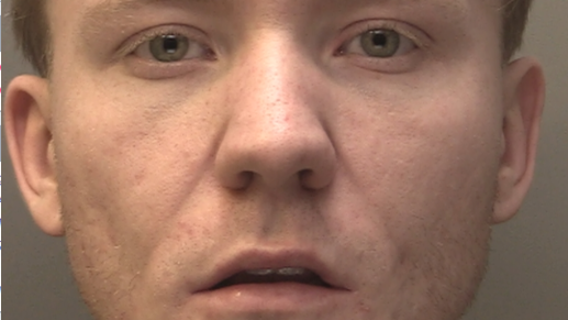 A police mugshot of Jamie Coggins, who has ginger hair and looks into the camera with a blank expression