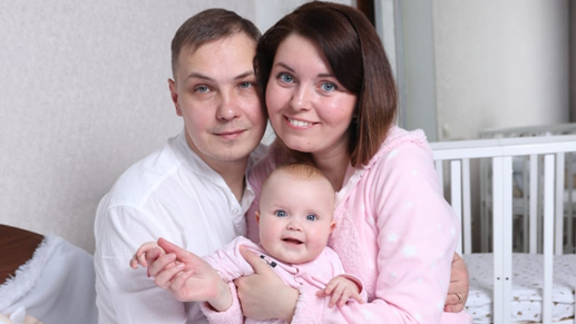 Family photo of Taisiia and her husband holding their baby