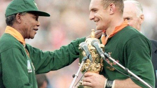 Francois Pienaar of South Africa receives the William Webb Ellis Trophy from President Nelson Mandela after the Rugby World Cup final between South Africa and New Zealand held on 24 June 1995