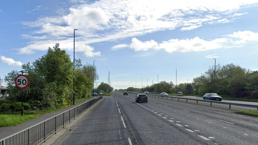 A dual carriageway with cars driving down it. There are 50mph speed limit signs.